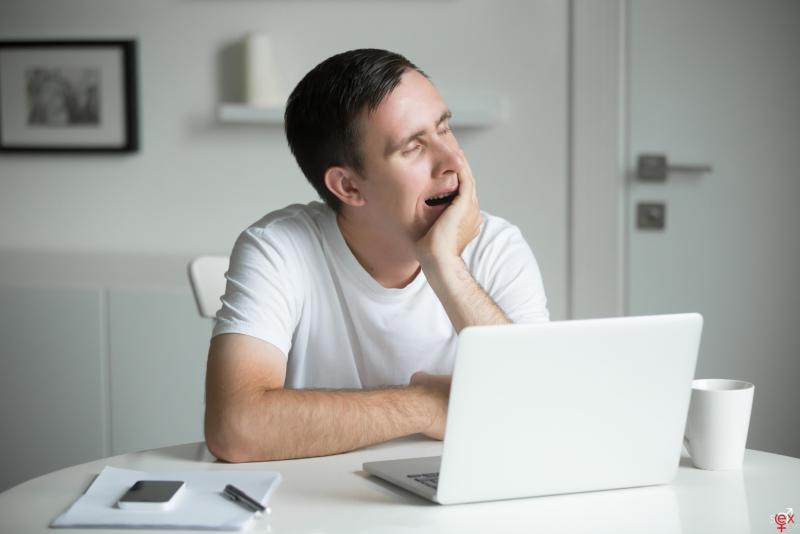 young-boring-yawn-man-sitting-white-desk-near-laptop.jpg